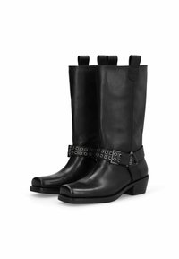 Botas de cuero negro hasta la rodilla con punta cuadrada, correa decorativa con ojales metálicos y tacón bajo tipo bloque. Incluyen tiradores para facilitar su calzado.