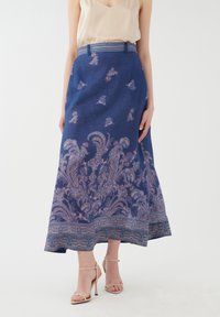 Langer, marineblauer Rock mit aufwendiger lila und rosa floraler Stickerei, einem taillierten Bund und einem gemusterten Saum. Das Material wirkt leicht.