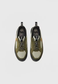 Grüne und graue Sportschuhe mit Mesh-Obermaterial, runder Zehenform, schwarzen Akzenten, gepolstertem Schaft und Gummisohle mit strukturiertem Profil.