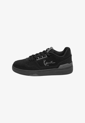 Fekete, velúrból készült sneaker, texturált felülettel. Szürke részletek és fűzők jellemzik, valamint egy jellegzetes aláírás az oldalon. Lapos gumitalp.
