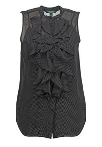 Blusa negra sin mangas con lunares blancos, detalle de volantes en la parte delantera y cierre de botones.