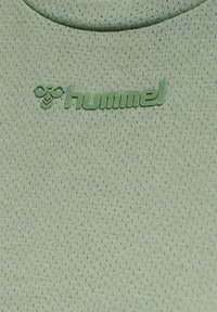 Ljusgrön träningsskjorta med texturerad tyg, som har en upphöjd, präglad "hummel"-logotyp i matchande färg.