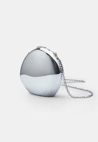 Borsa clutch in argento metallico con forma arrotondata a mezzaluna, dotata di chiusura a scatto e tracolla a catena rimovibile. Texture liscia.