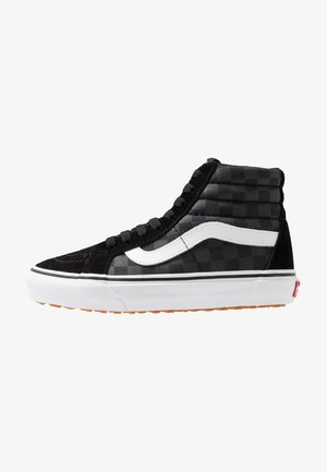 Zapatilla alta de cuadros negros y grises con franja lateral blanca, cordones negros, suela blanca y suela exterior de goma natural.