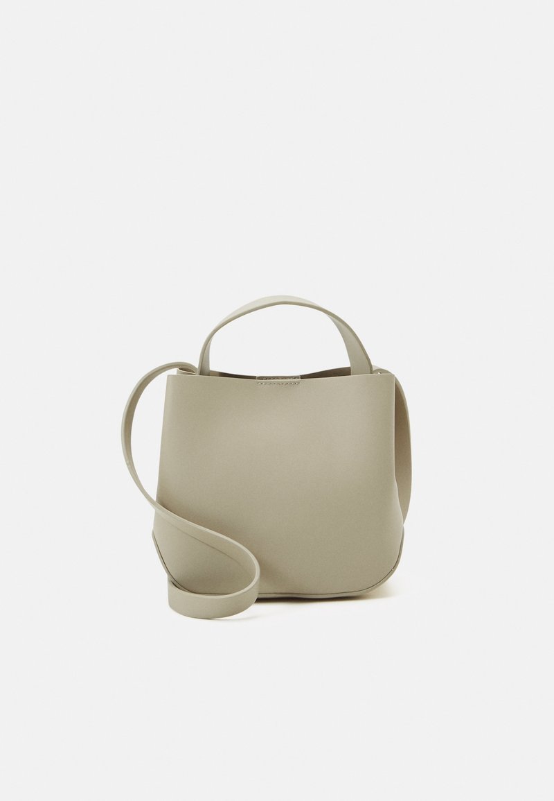 Borsa morbida di colore grigio-verde con una texture liscia, forma rotonda, manici corti e una lunga tracolla regolabile. Design minimalista.