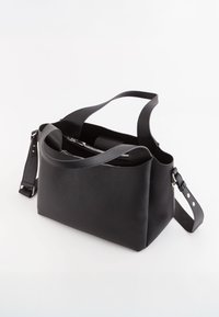 Sort læder tote bag med en struktureret overflade. Har to håndtag og en aftagelig rem med metalliske detaljer. Lynlåslomme indeni.