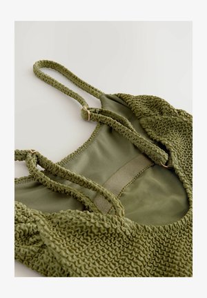 Costume da bagno verde in tessuto testurizzato con arricciature, spalline regolabili e una fodera interna liscia. Accenti in metallo dorato.
