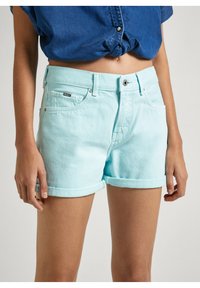 Pantalones cortos de mezclilla azul claro con dobladillo enrollado, con bolsillos frontales, cierre de botón y una pequeña etiqueta de la marca en la cintura.
