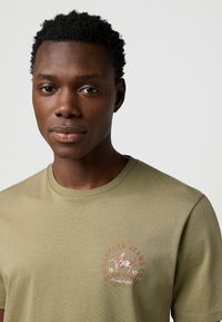 Wrangler SHORT SLEEVE SMALL GRAPHIC TEE - REGULAR FIT - Camiseta estampada - aloe