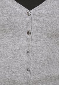 Grå cardigan med V-hals, ribbet krage og frontknapper. Myk strikket tekstur, fem knapper synlige, enkelt design uten mønstre.
