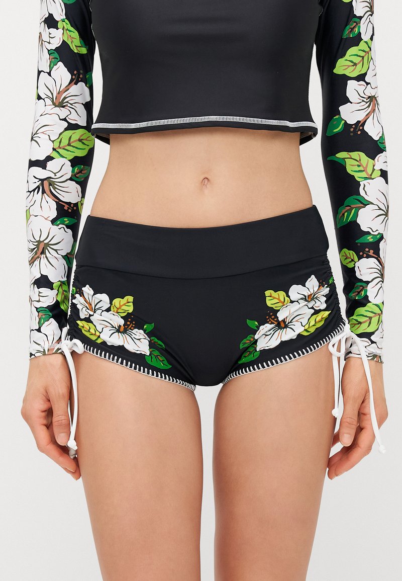 Black swim top with long floral-printed sleeves, paired with black shorts featuring white floral patterns and side ties. Smooth fabric texture.