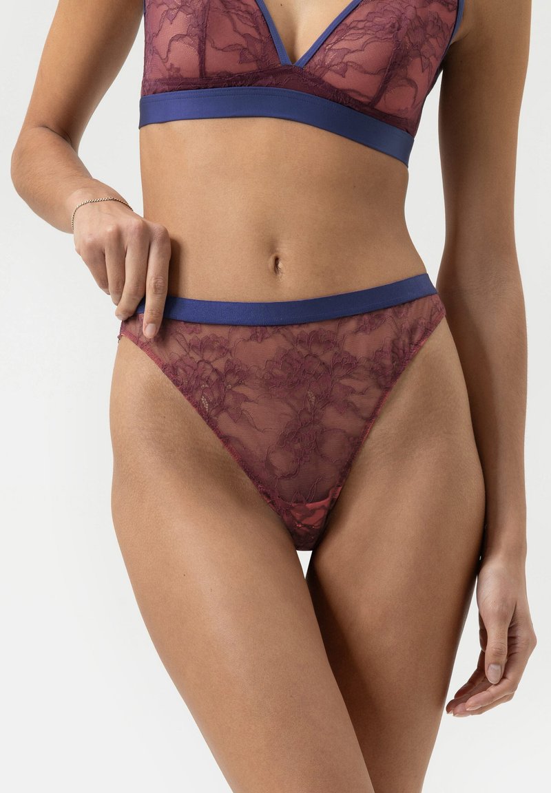 Bordeaux kanten bh en bijpassende string met een blauwe satijnen tailleband. Bloemenpatroon, doorzichtige textuur, met een V-hals ontwerp.