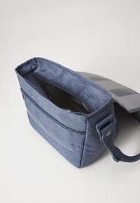 Borsa a tracolla in tessuto blu con chiusura a zip, tracolla regolabile e dettagli grigio chiaro. L'interno presenta una fodera testurizzata e un ampio scomparto.