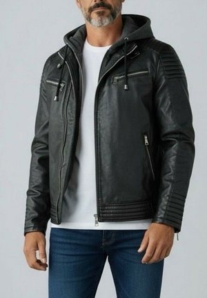 Veste en cuir noire avec capuche, dotée de poches zippées, de détails côtelés aux épaules et d'une texture lisse. Portée sur une chemise blanche.
