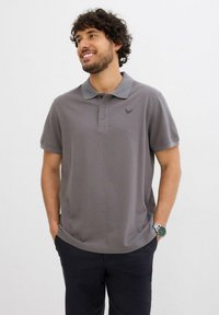 Polo grigia in cotone con colletto, chiusura a tre bottoni e una piccola stampa del logo sul petto. Maniche corte, vestibilità casual.