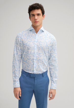 Chemise à boutons bleu clair à motif floral avec manches longues, faite d'un tissu texturé, assortie à un pantalon bleu uni.