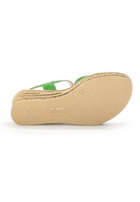Sandale en daim vert à talon compensé avec une semelle en caoutchouc naturel, présentant une finition texturée et un logo embossé. Design ouvert avec des sangles autour de la cheville.