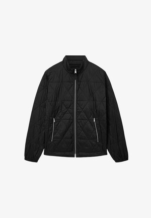 Mustat tikatut takki korkealla kauluksella, edessä vetoketju ja kaksi vetoketjullista taskua. Materiaali on sileäpintainen ja siinä on timanttikuosi.