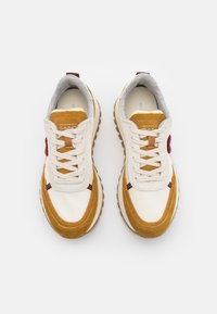 Sneaker mit einem Obermaterial aus cremefarbener Leder, goldenen Wildlederakzenten, grauem Futter und weißen Schnürsenkeln. Gummisohle mit Profil für besseren Halt.