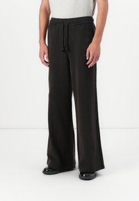 Marimekko PUUSKA VIHKIRUUSU PLACEMENT UNISEX - Tracksuit bottoms - dark brown