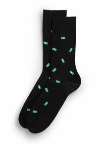 Sorte crewsokker med et mønster af små grønne dollarbilletter spredt over stoffet.
