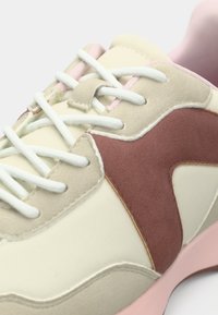 Κρέμ και ροζ αθλητικό παπούτσι με λείο δερμάτινο επάνω μέρος, σουέντ λεπτομέρειες σε σκούρο ροζ, λευκά κορδόνια, επενδεδυμένο γιακά και υφασμένη σόλα.