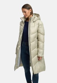 Lys beige pufferjakke med hette, med glidelås foran, quiltet design og to sidelommer. Materialet ser glatt og skinnende ut.