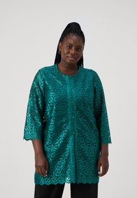 Turquoise kanten top met driekwarts mouwen, ingewikkeld bladerenpatroon, ronde halslijn en gegolfde zoom, met knoopsluitingen.