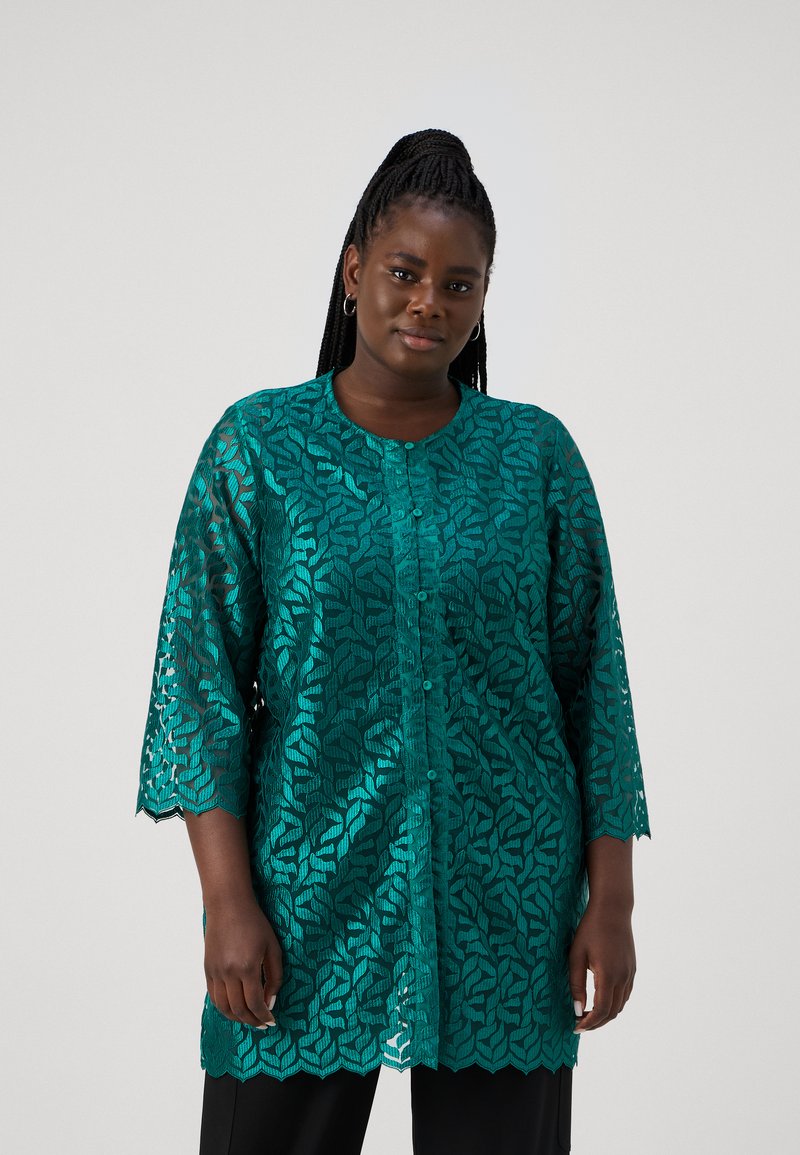 Turquoise kanten top met driekwarts mouwen, ingewikkeld bladerenpatroon, ronde halslijn en gegolfde zoom, met knoopsluitingen.