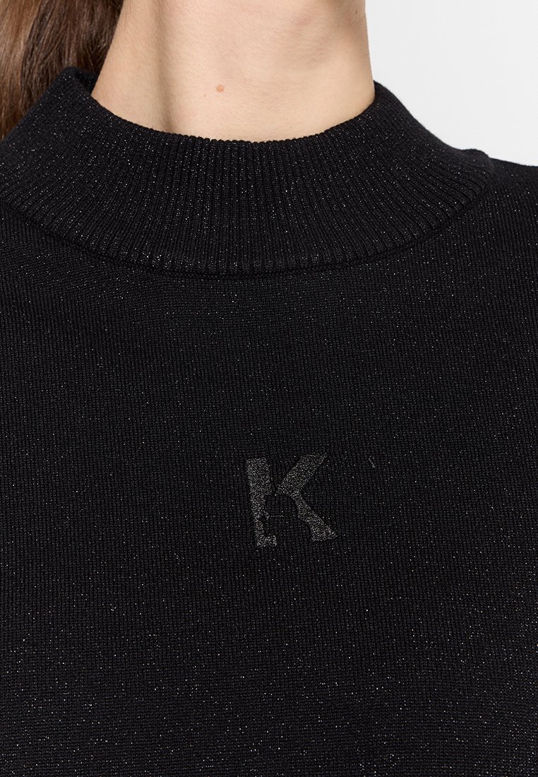 Czarny sweter z prążkowanego dzianiny z golfem, lekko błyszczący, z małym wytłoczonym logo 'K' z przodu.