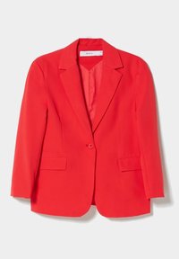 Punainen bleiseri, jossa on räätälöity leikkaus, yksirivinen nappisuljenta, lovetut kaulukset ja sivutaskut. Sileä kangas ja jäsennelty muoto.