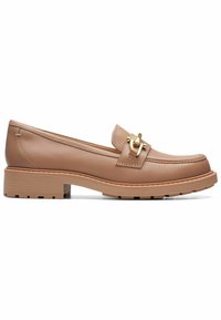 Mocassin en cuir beige avec semelle épaisse, boucle métallique dorée sur le dessus et coutures détaillées le long des bords et de la semelle.