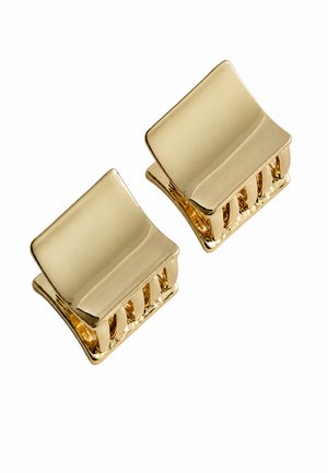 Twee kleine glanzende gouden vierkante haarspeldjes met gebogen randen op een witte achtergrond.