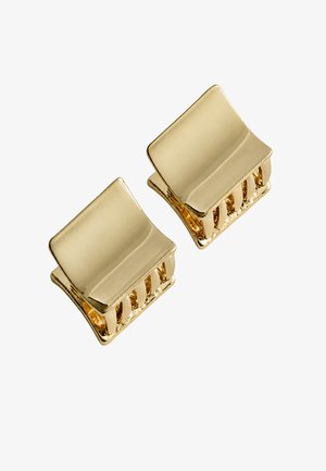 Twee kleine glanzende gouden vierkante haarspeldjes met gebogen randen op een witte achtergrond.