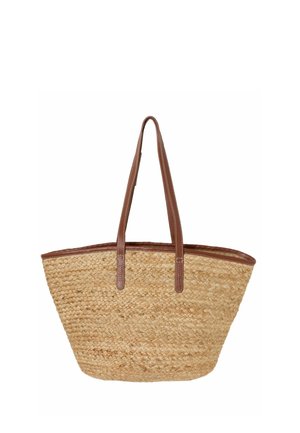 Gevlochten strooien totebag met brede, gestructureerde body en bruine leren handvatten en afwerking, ontworpen voor het dragen over de schouder.