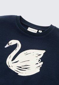 Granatowy sweter z okrągłym dekoltem z dużym, białym grafika łabędzia. Miękka tekstura, z trwałym włóknem bawełnianym. Markowy produkt: Tom Tailor.