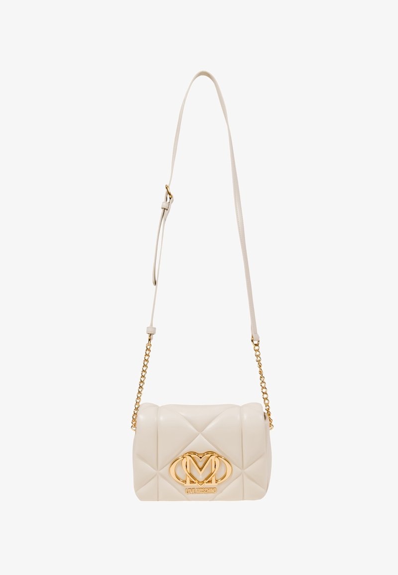 Borsa a tracolla color crema trapuntata con catena dorata, caratterizzata da un prominente badge logo dorato sulla parte anteriore e una superficie liscia e lucida.