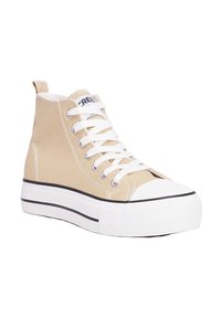 Zapatillas altas hechas de lona color beige con cordones blancos, puntera de goma y una suela blanca gruesa con acentos negros.