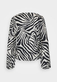 Μπλούζα με μακριά μανίκια, διακοσμημένη με μπεζ και μαύρο σχέδιο ζέβρας, κατασκευασμένη από ελαφρύ ύφασμα με άνετη εφαρμογή και στρογγυλή λαιμόκοψη.