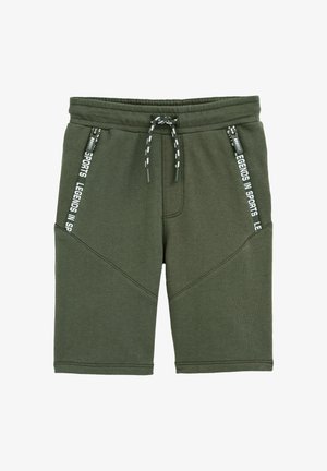 Oliven grønne atletiske shorts lavet af blødt stof, med snor i taljen, to lynlåslommer og hvid tekstdetalje på siderne.