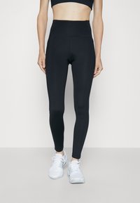 Aukštos juosmens juodos leggings, su lygiu pavir�šiumi ir pilno ilgio fasonu. Suderinti su baltais sportiniais batais. Paprastas ir elegantiškas dizainas.