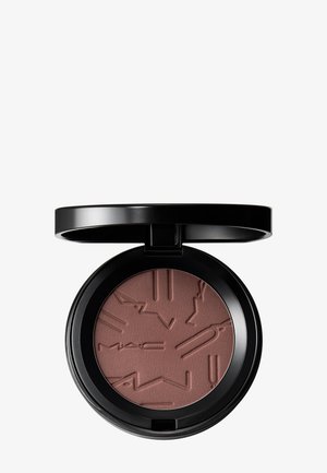 Round black compact with open lid showing matte brown pressed powder embossed with geometric and MAC logo patterns.