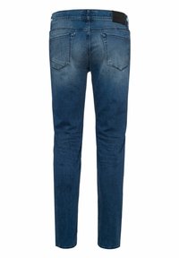 Slim-fit blue denim jeans with a faded wash, five pockets, and a leather brand patch on the waistband. Straight leg design.