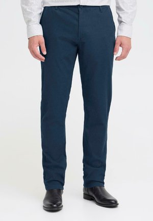 Navy blauwe chino's gemaakt van een katoenmix, met een slim fit ontwerp, riemlussen en voorzakken. Gecombineerd met zwarte laarzen.