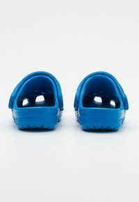 Zili koka ar gludu, spīdīgu virsmu. Atvērta aizmugure ar ventilācijas caurumiem un strukturētu zoli. Viegls, elastīgs materiāls.