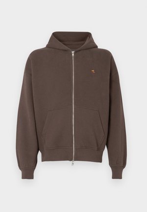 Hanorac cu fermoar de culoare maro, cu un buzunar frontal, glugă și manșete cu nervuri. Prezintă un mic design brodat în zona stângă a pieptului.