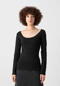 Camiseta negra de manga larga con escote en pico, hecha de un tejido suave. Presenta un diseño ajustado y una textura suave. Ideal para superponer.