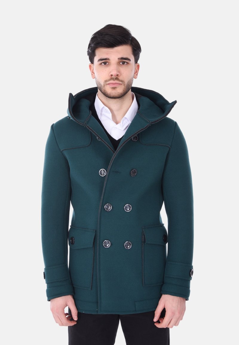 Cappotto peacoat verde scuro con cappuccio, frontale doppiopetto, bottoni neri visibili e tasche frontali. Texture liscia, vestibilità su misura.