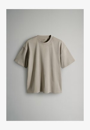 Short-sleeve t-shirt in light beige, made from soft cotton fabric. Crew neckline with relaxed fit and minimalistic design. No visible patterns.