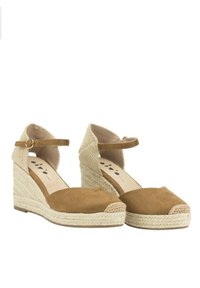 Alpargatas de cuña con un upper de ante marrón y tacón de yute trenzado, que cuentan con una correa en el tobillo y una punta redondeada con un borde de yute trenzado.
